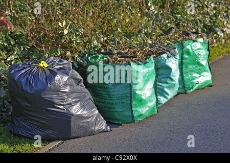 Déchets de jardin et déchets ménagers sur la chaussée en attente de collecte par le Conseil de district de Wokingham, Reading, Berkshire, Royaume-Uni Banque D'Images