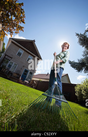 Low angle view of senior woman holding rake Banque D'Images