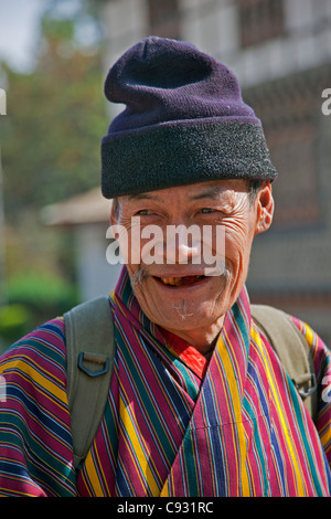 Un vieil homme au port du Trashigang gho traditionnel robe de tous les hommes bhoutanais. Banque D'Images