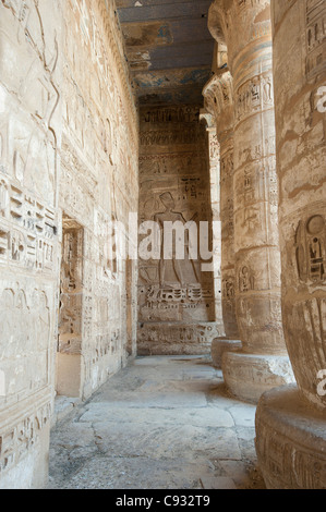 Sculptures hiéroglyphique égyptienne sur un mur dans le temple de Medinat Habu à Louxor avec des colonnes Banque D'Images