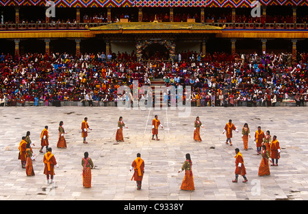 Le Bhoutan, Thimphu. Danseurs portant des Bhoutanais traditionnel effectuer robe dans une cour à côté Trashi Chhoe Dzong. Banque D'Images