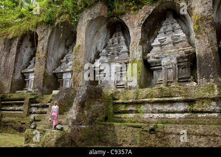 Bali, Ubud. Un touriste contemple l'énorme sanctuaires creusées à même la falaise face au Temple de Gunung Kawi. M. Banque D'Images