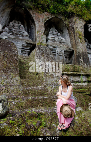 Bali, Ubud. Un touriste contemple l'énorme sanctuaires creusées à même la falaise face au Temple de Gunung Kawi. M. Banque D'Images