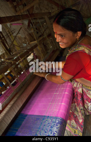 Une femme tisse un beau sari sur un métier traditionnel en bois à Santipur village sur les rives de la rivière Hooghly. Banque D'Images