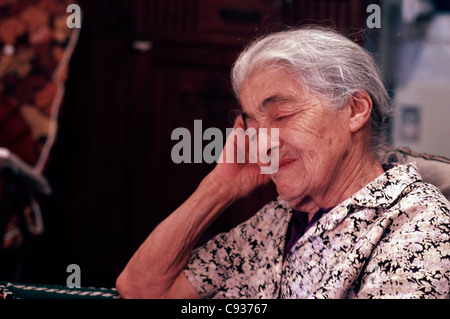 Vieille dame endormi assis dans un fauteuil Banque D'Images