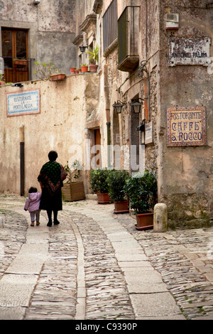 La Sicile, l'Italie, l'Europe de l'Ouest ; Une vieille femme et sa petite-fille marche dans l'une des vieilles rues de Erice Banque D'Images