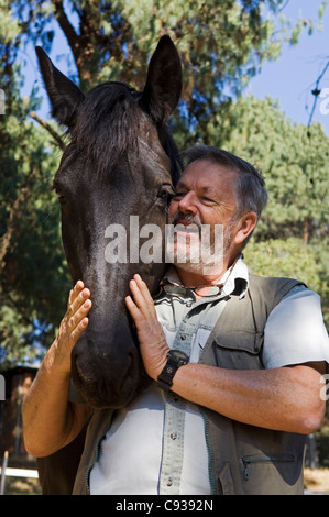 Plateau de Zomba, Malawi. Brian Parsons, propriétaire d'écuries du plateau, avec son cheval. Banque D'Images