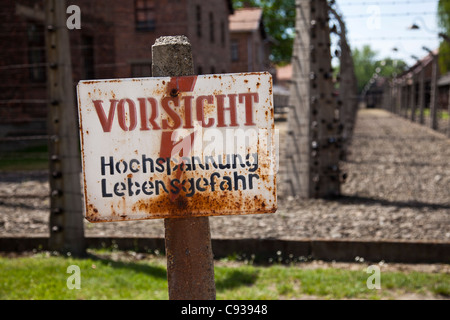 La Pologne, Oswiecim, Auschwitz I camp de concentration. 'Attention' signe haute tension électrique par du fil de fer barbelé clôture de périmètre. Banque D'Images