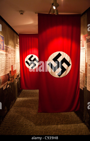 Pologne, Cracovie. Drapeaux à croix gammée du parti nazi allemand, d'expositions dans le musée de Schindler. Banque D'Images