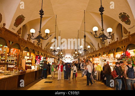 Pologne, Cracovie. Les touristes dans le marché de souvenirs dans la Halle aux Draps, Place du marché. Banque D'Images