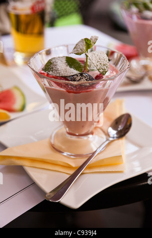 Pologne, Cracovie. Une framboise et prune milkshake décoré de monnaie de Camelot, un célèbre café à Cracovie. Banque D'Images