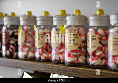 Maison de vacances à saveur de fraise stick rock dans des bocaux et des sacs de bonbons pour la vente, le parfait cadeau de Holiday Beach et d'aujourd'hui. Banque D'Images