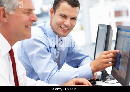 Les hommes d'affaires travaillant sur des ordinateurs Banque D'Images