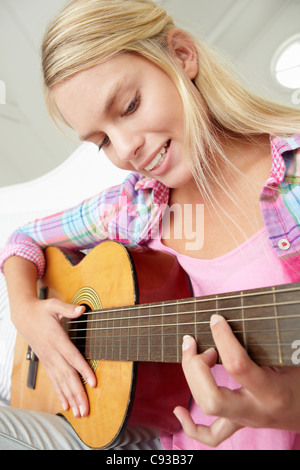 Teenage girl playing acoustic guitar Banque D'Images