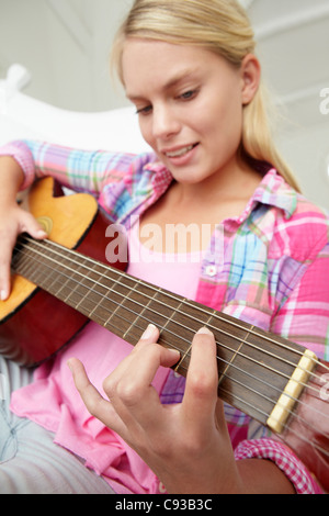 Teenage girl playing acoustic guitar Banque D'Images