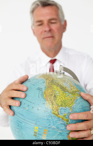 Senior businessman holding globe