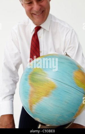 Senior businessman globe en rotation Banque D'Images