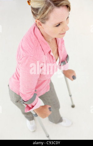 Femme marche avec des béquilles Banque D'Images