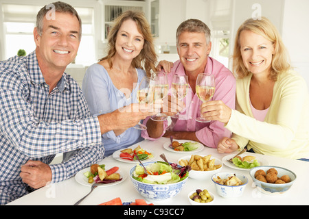 L'âge moyen des couples enjoying meal at home Banque D'Images