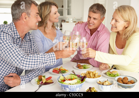 L'âge moyen des couples enjoying meal at home Banque D'Images