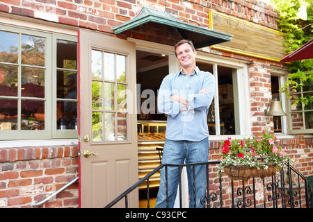 Homme debout à l'extérieur de boulangerie/cafÃ© Banque D'Images