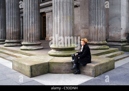 Femme assise à l'extérieur de la galerie d'Art Moderne, Goma, Royal Exchange Square, Glasgow, Écosse, Royaume-Uni Banque D'Images