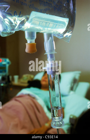 Female patient in hospital bed connecté à IV Banque D'Images