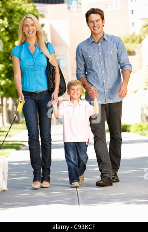 Family walking with dog in city street Banque D'Images