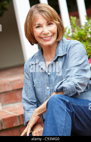 Mid age woman relaxing in garden Banque D'Images