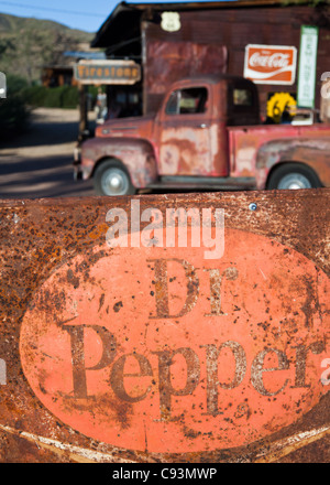 Old rusty Dr Pepper signe dans le premier plan avec un camion vintage dans l'arrière-plan à l'extérieur de micocoulier, magasin général sur l'historique Route 66, Arizona, USA Banque D'Images