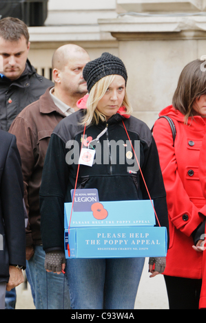 Femme vendant du Royal British Legion coquelicots observe les deux minutes de silence pour le Jour du Souvenir. 11/11/2011 BELFAST Banque D'Images