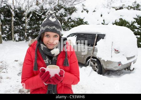 Jeune femme dans la neige avec voiture Banque D'Images