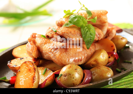Ailes de poulet et pommes de terre saupoudrée de ciboulette Banque D'Images