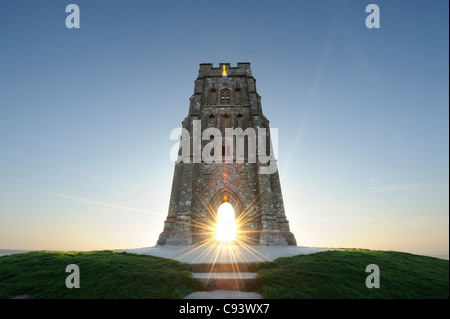 St Michael's tower au sommet de Tor de Glastonbury, Somerset, avec le soleil levant visible à travers l'arcade. Banque D'Images