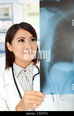 Médecin asiatique l'examen aux rayons x dans le bureau du médecin Banque D'Images