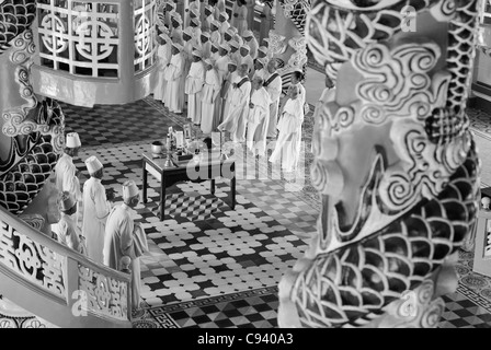 L'Asie, Vietnam, Tay Ninh. Saint-siège caodaïste de Tay Ninh. Les Cao Dai cérémonie dans la salle de prière du Temple divin de ... Banque D'Images