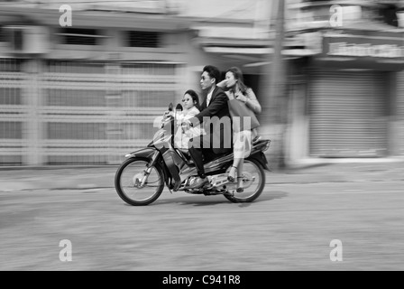 L'Asie, Vietnam, Hanoi. Vieux quartier de Hanoi. Smartly dressed famille vietnamienne avec fille se précipiter sur moto par Hanoï. Banque D'Images