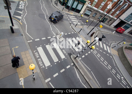 Vue aérienne d'un taxi orné d'un motif Union Jack à un passage à zèbre avec des balises Belisha près du Barbican dans le centre de Londres, Royaume-Uni Banque D'Images