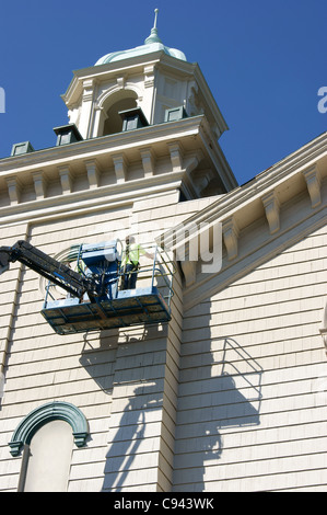 Faible angle de vue d'un homme sur la peinture d'une grue à tour la Columbia Street Baptist Church, Bangor, Maine. Banque D'Images