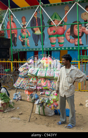 Vente de jouets en plastique bon marché de l'homme, en face d'un parc d'exposition anormale, Pushkar Mela, Pushkar, Rajasthan, India Banque D'Images