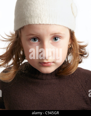 Portrait d'une triste petite fille regardant la caméra isolé sur blanc. Banque D'Images