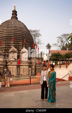 L'Inde, de l'Assam, Guwahati, temple Kamakhya, jeune couple de pèlerins, des guirlandes de fleurs en face de l'Shikara Banque D'Images