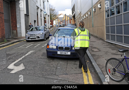 Le trafic des femmes directrice de donner une voiture un ticket pour le parking sur double lignes jaunes Brighton UK Banque D'Images