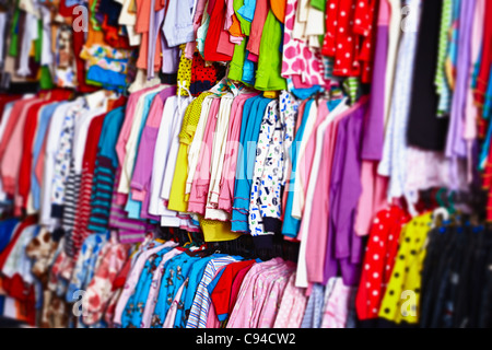 Bébé Vêtements colorés sur des cintres suspendus dans un magasin Banque D'Images