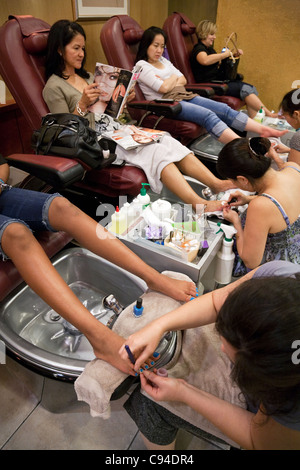 Les femmes ayant une pédicure dans un bar à ongles, Washington DC USA Banque D'Images