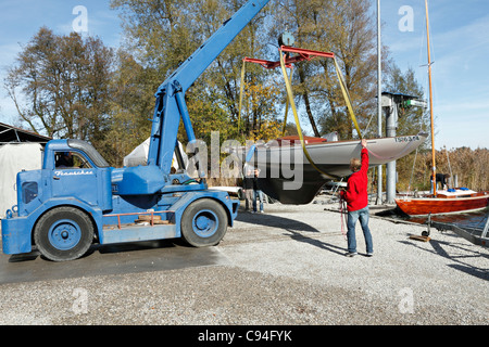 Levage par grue mobile un voilier, Chiemgau Haute-bavière Allemagne Banque D'Images