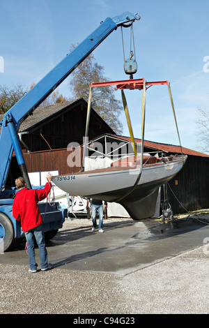 Levage par grue mobile un voilier, Chiemgau Haute-bavière Allemagne Banque D'Images