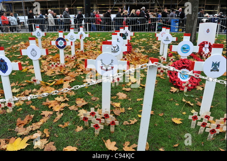 Des croisements avec des coquelicots sur eux dans le jardin du souvenir que les foules se rassemblent à Glasgow's George Square à payer de silence en hommage aux soldats qui ont donné leur vie durant la Première Guerre mondiale et la seconde guerre mondiale et d'autres guerres depuis. Banque D'Images