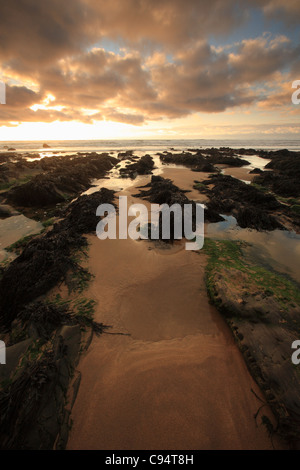 Automne coucher de soleil sur des roches à Sandymouth Bay, North Cornwall, England, UK Banque D'Images