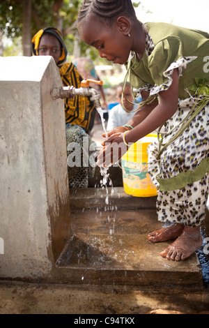 Un enfant se lave les mains à un puits communautaire à Dar es Salaam, Tanzanie, Afrique de l'Est. Banque D'Images